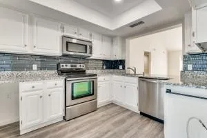 a kitchen with stainless steel appliances granite countertop a stove a sink and a microwave