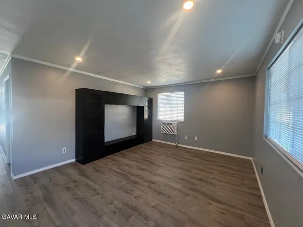 an empty room with windows and fireplace