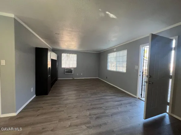 a view of empty room with window and wooden floor
