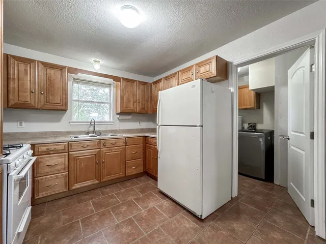 a kitchen with a refrigerator sink and cabinets
