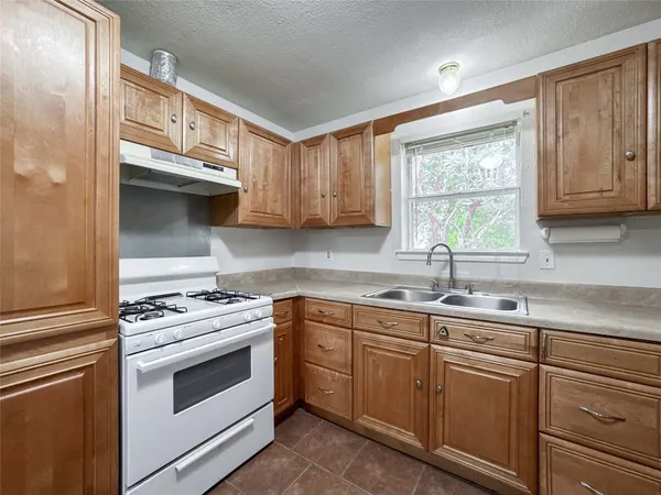 a kitchen with stainless steel appliances granite countertop a sink a stove and cabinets