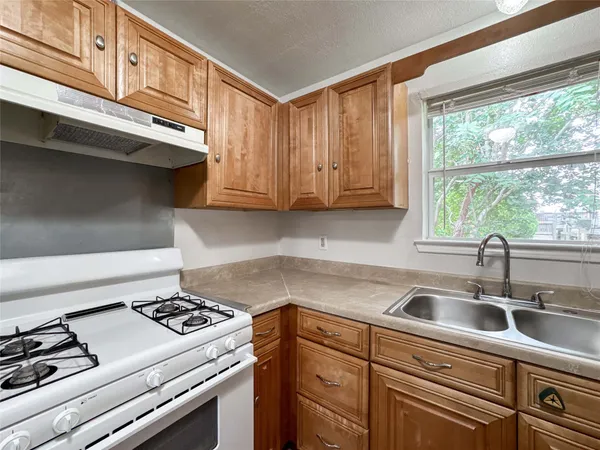 a kitchen with stainless steel appliances a sink stove and cabinets