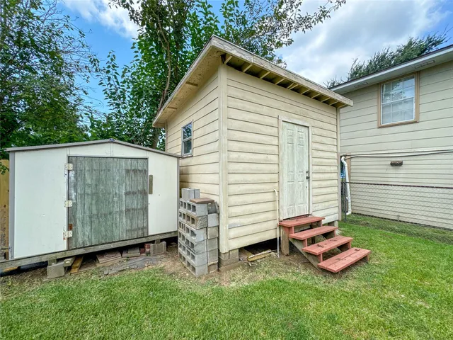 a view of a small house with backyard