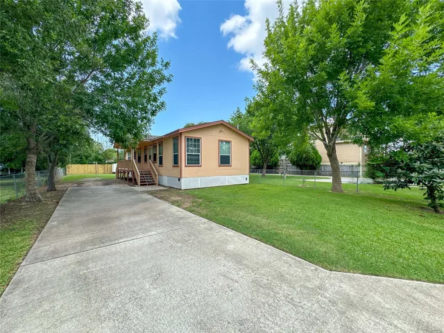 a view of a house with backyard and a tree