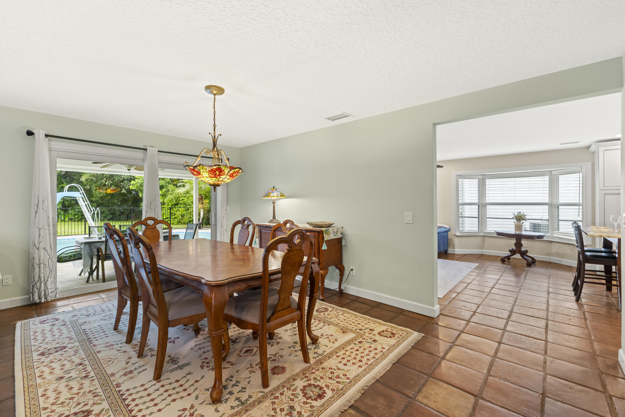 6595 Wood Lake Road Jupiter, FL 33458 - Photo 11 of 54 a dining room with furniture a chandelier and wooden floor