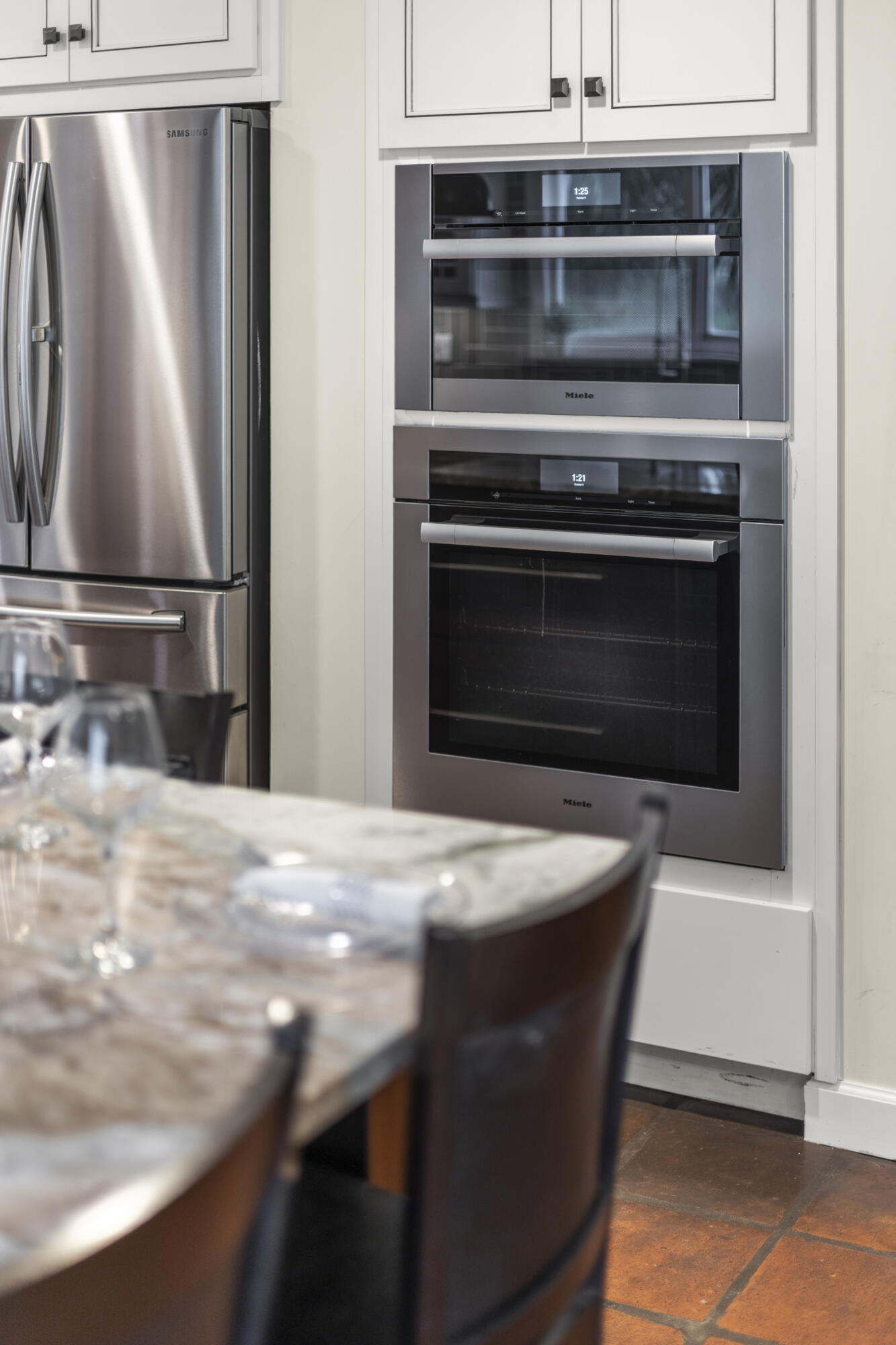 6595 Wood Lake Road Jupiter, FL 33458 - Photo 17 of 54 a kitchen with kitchen island a stove and a refrigerator with white cabinet