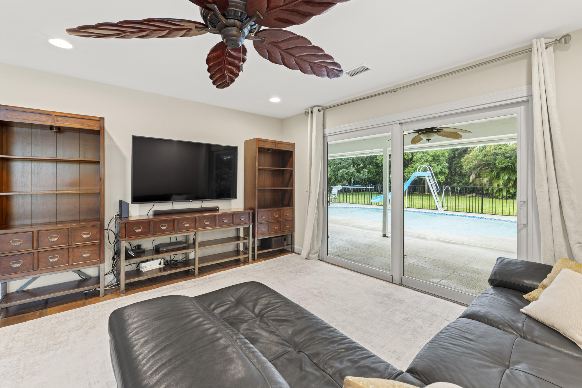 6595 Wood Lake Road Jupiter, FL 33458 - Photo 25 of 54 a bedroom with furniture and a flat screen tv