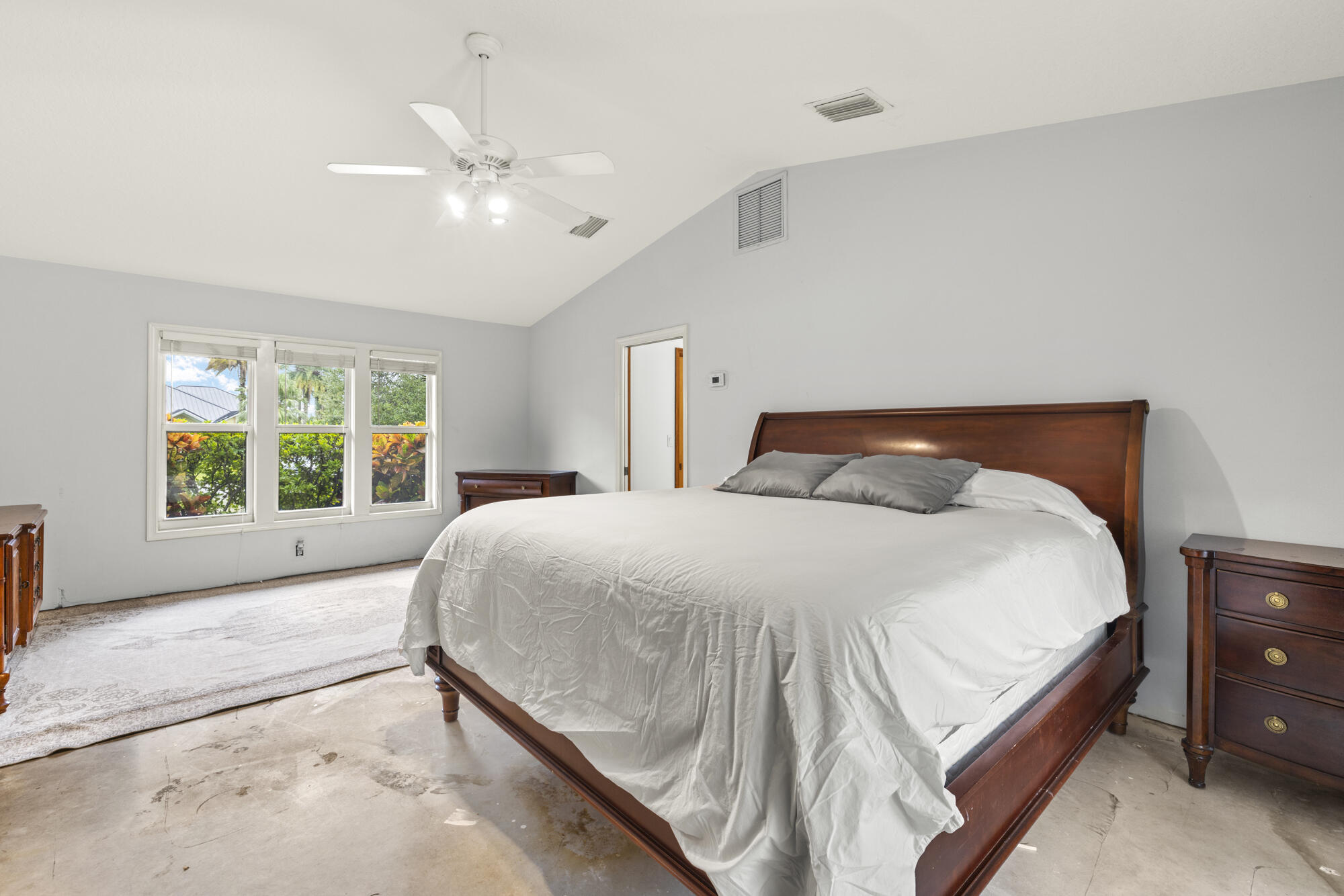 6595 Wood Lake Road Jupiter, FL 33458 - Photo 26 of 54 a bedroom with a large bed and a chandelier