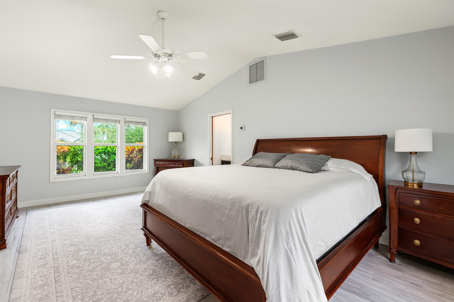 6595 Wood Lake Road Jupiter, FL 33458 - Photo 27 of 54 a bedroom with a bed and large window