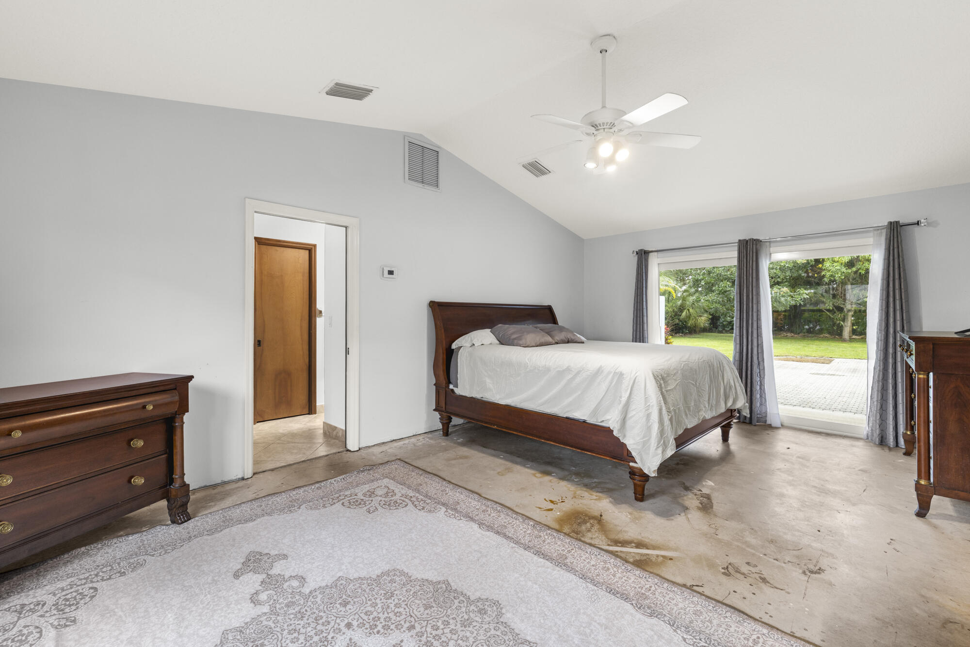 6595 Wood Lake Road Jupiter, FL 33458 - Photo 28 of 54 a bedroom with a large bed and a chandelier