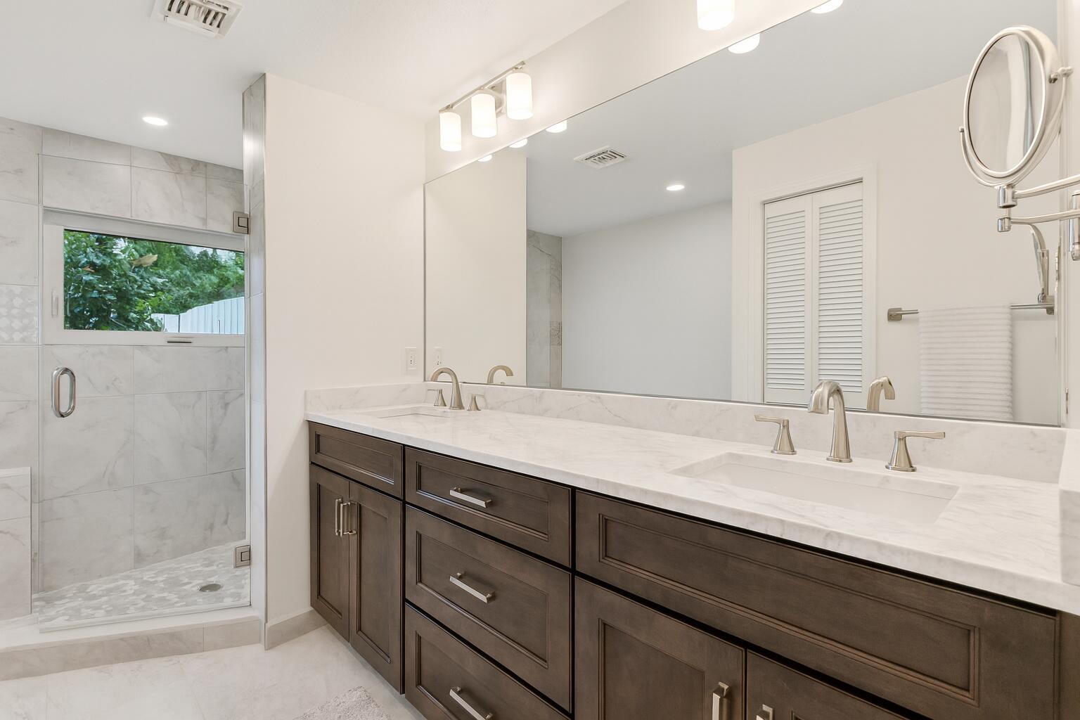 6595 Wood Lake Road Jupiter, FL 33458 - Photo 31 of 54 a bathroom with a double vanity sink mirror and shower