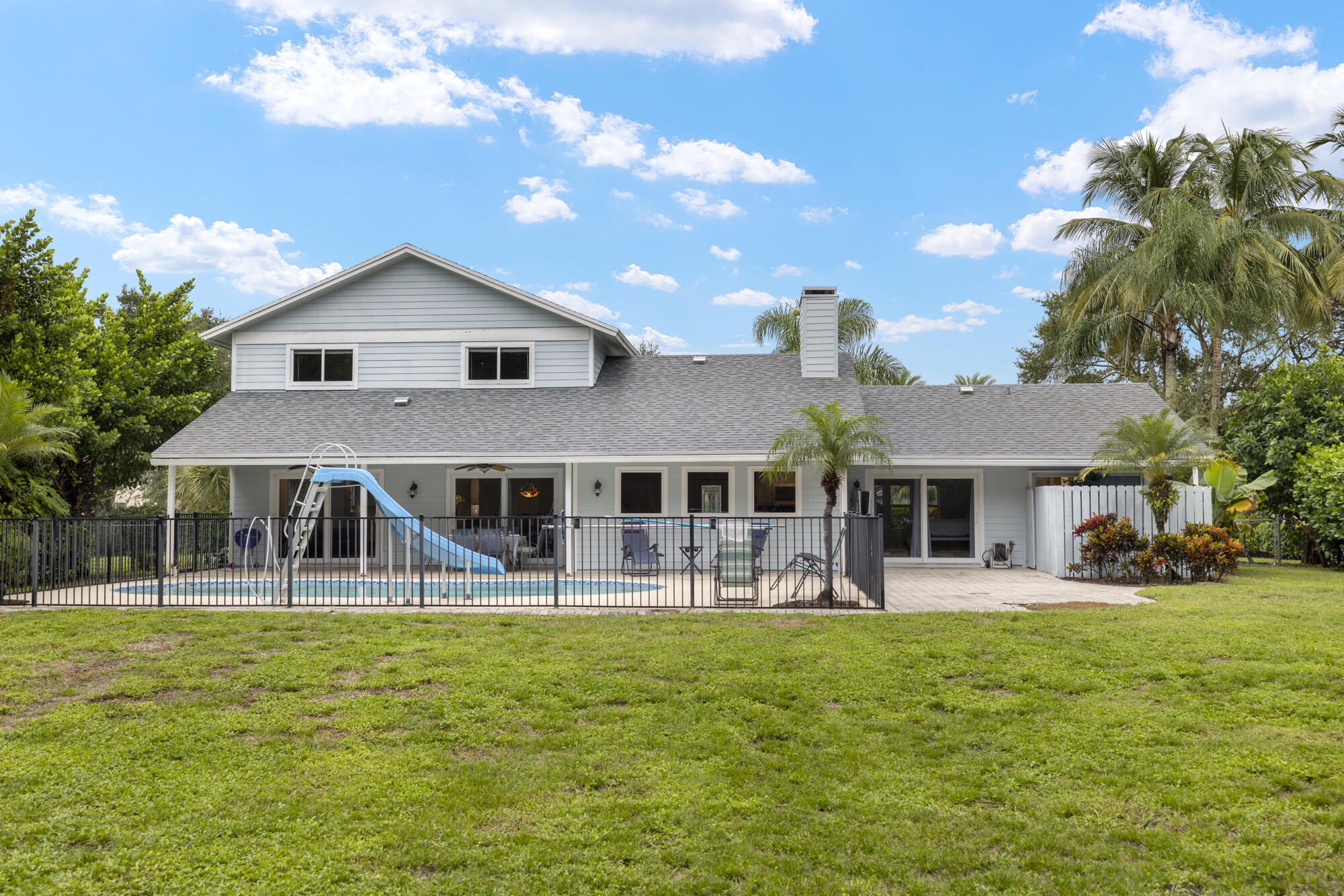 6595 Wood Lake Road Jupiter, FL 33458 - Photo 40 of 54 a front view of a house with garden