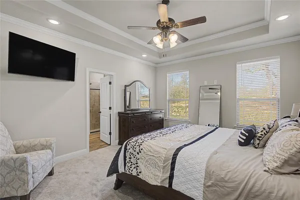 a bedroom with a bed a tv and wooden floor