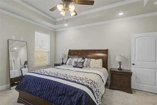 a bedroom with a large bed and a chandelier