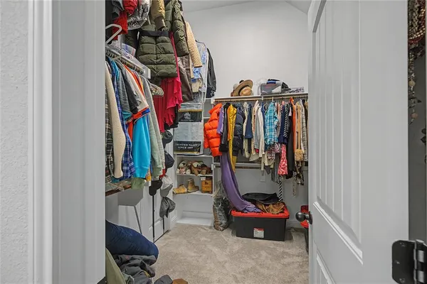 a view of walk in closet with clothes
