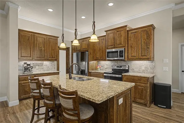 a kitchen with a stove a sink and chairs