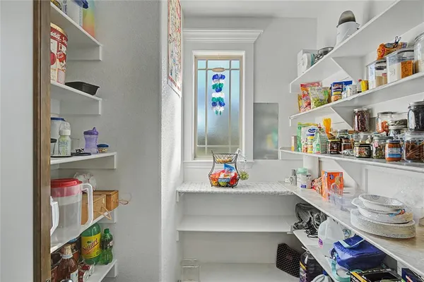 a utility room with fridge and a window