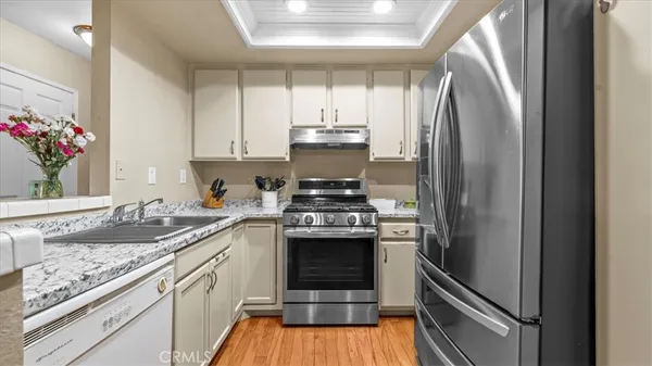 a kitchen with stainless steel appliances granite countertop a sink stove and refrigerator