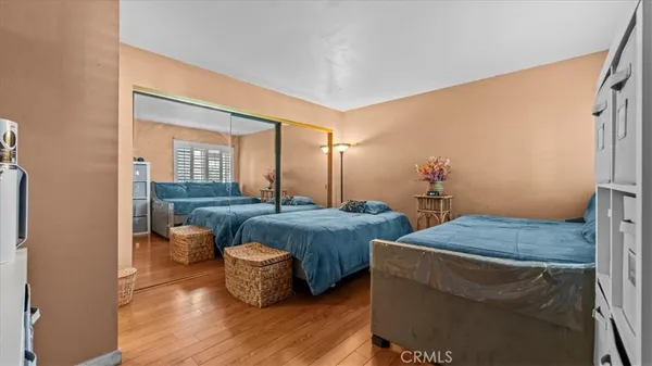 a bedroom with two beds and wooden floor