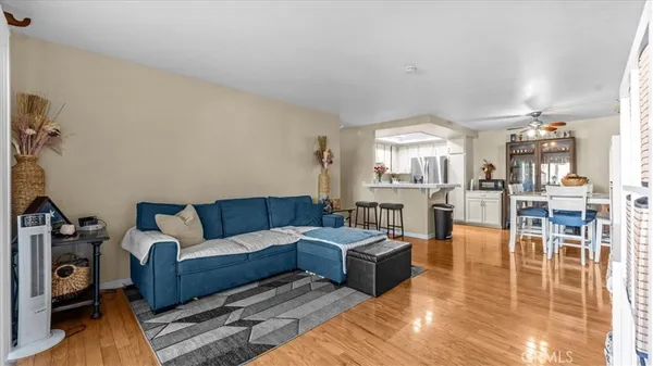 a living room with furniture wooden floor and a large window