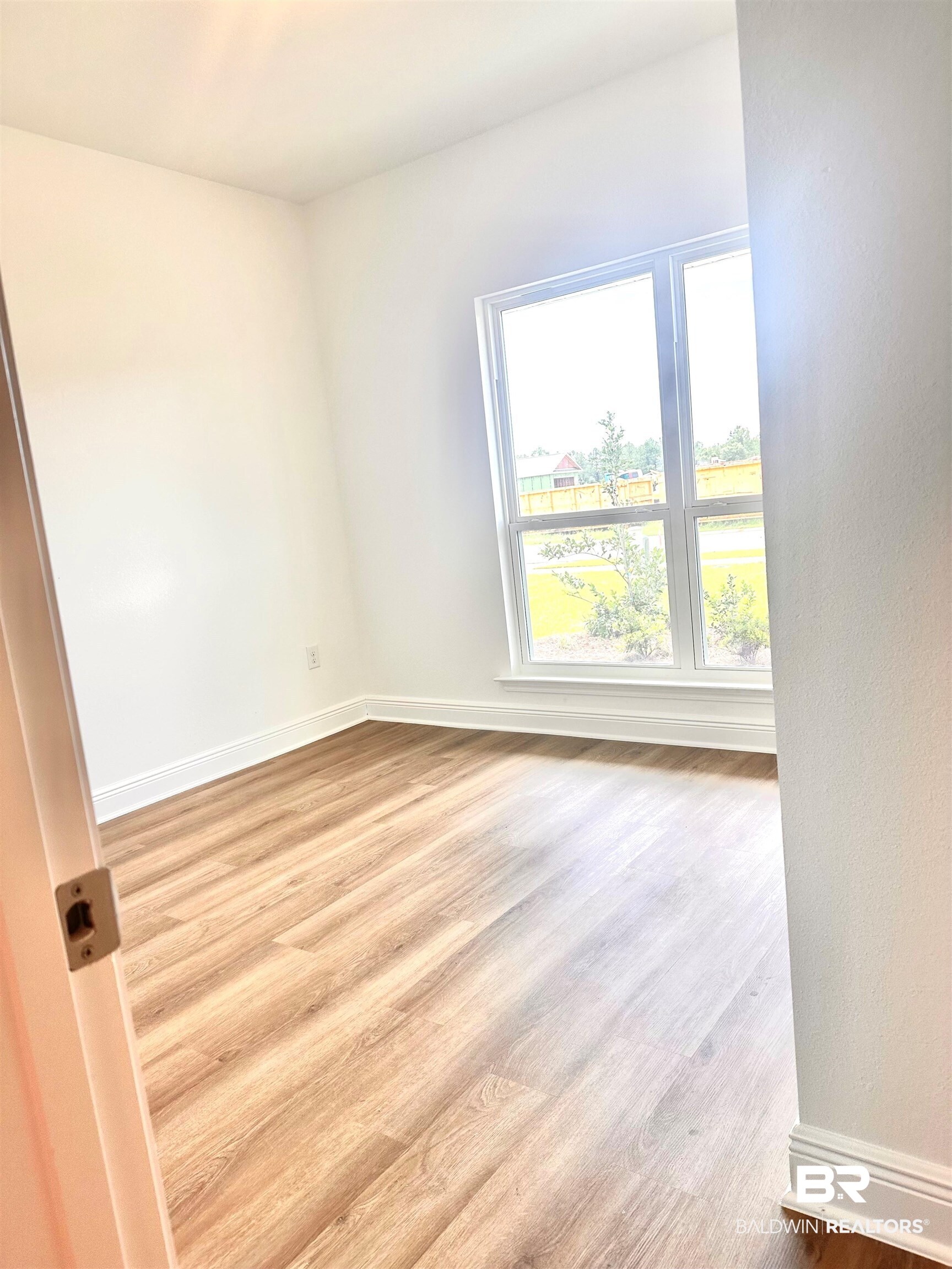 12905 Grand Rpds Road Fairhope, AL 36532 - Photo 16 of 29 Empty room featuring light wood-type flooring and a healthy amount of sunlight