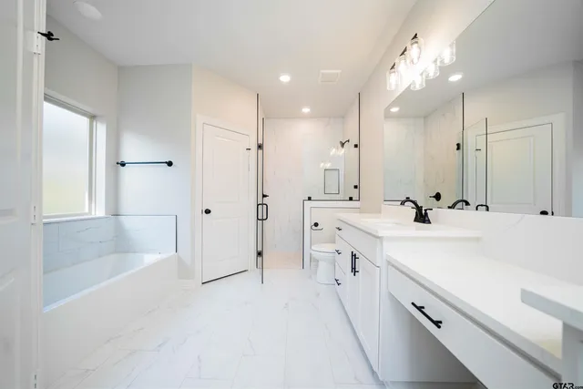 a spacious bathroom with a double vanity sink a mirror and a bathtub