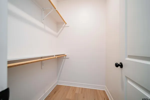 an empty room with a window and a ceiling fan