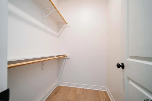 an empty room with a window and a ceiling fan