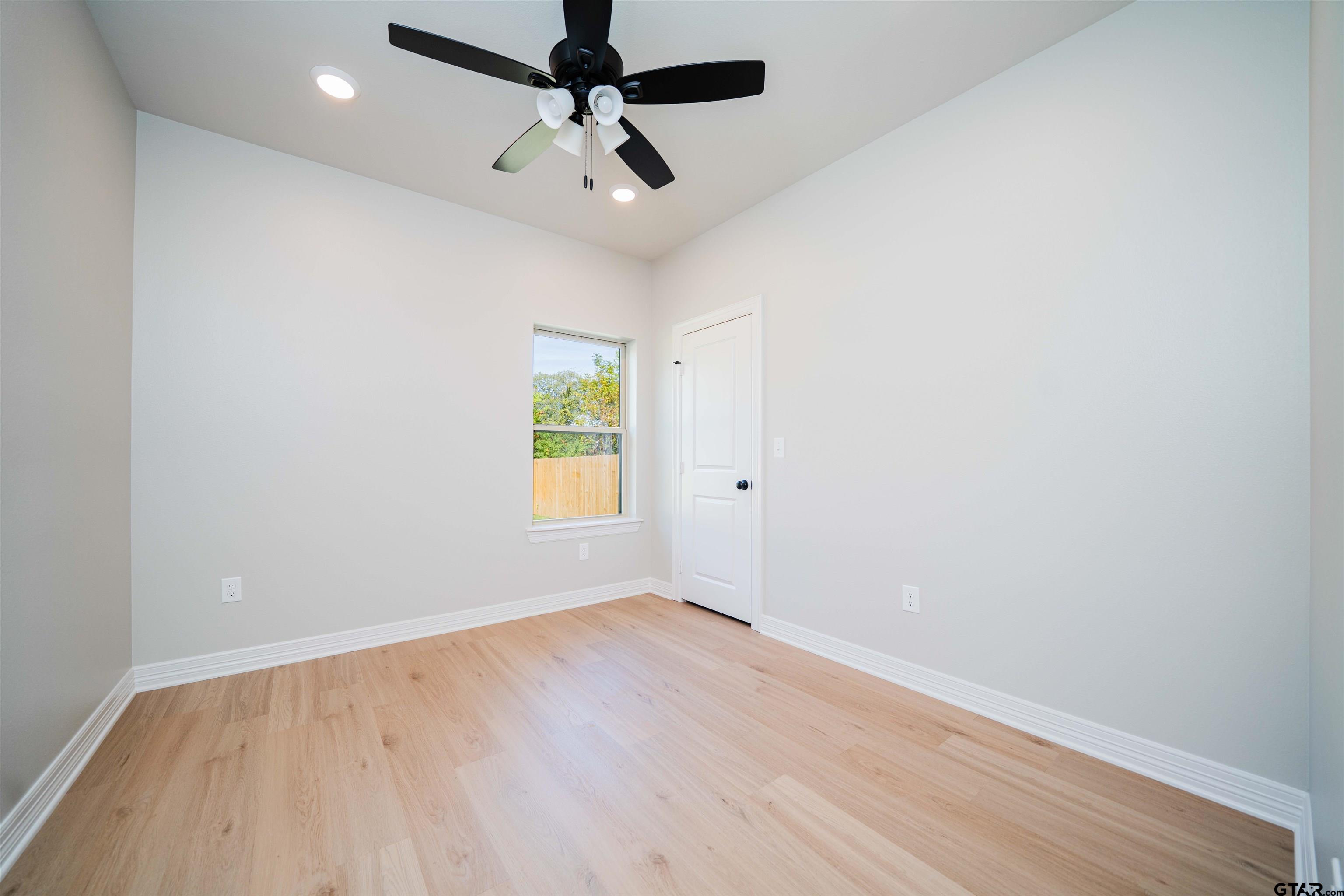 1203 Penny Lane Kilgore, TX 75662 - Photo 18 of 24 an empty room with a window and a ceiling fan