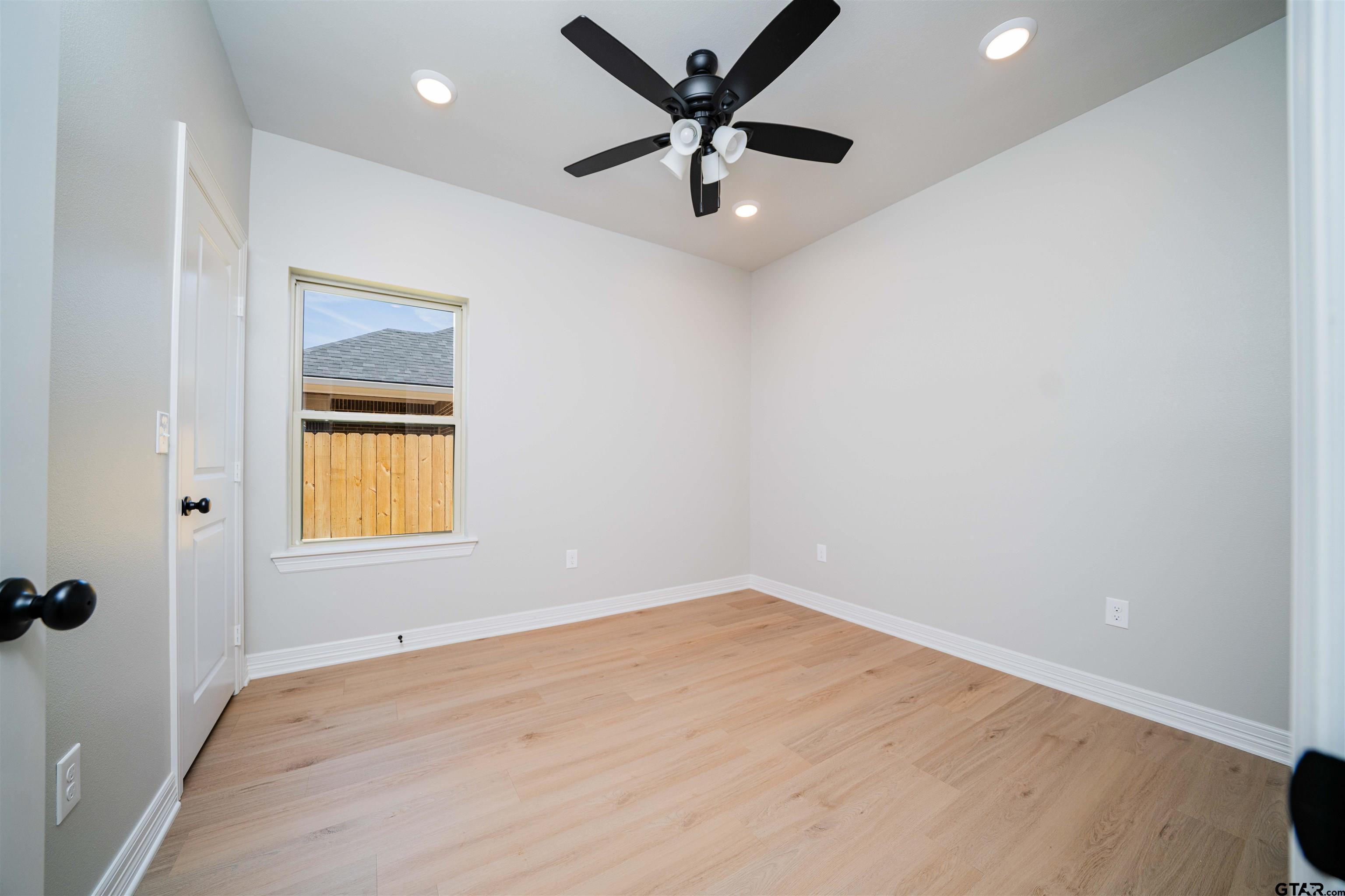 1203 Penny Lane Kilgore, TX 75662 - Photo 19 of 24 an empty room with a window and a ceiling fan