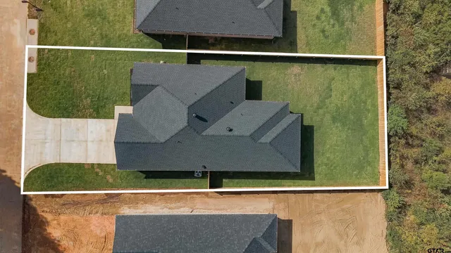 an aerial view of a house with a yard