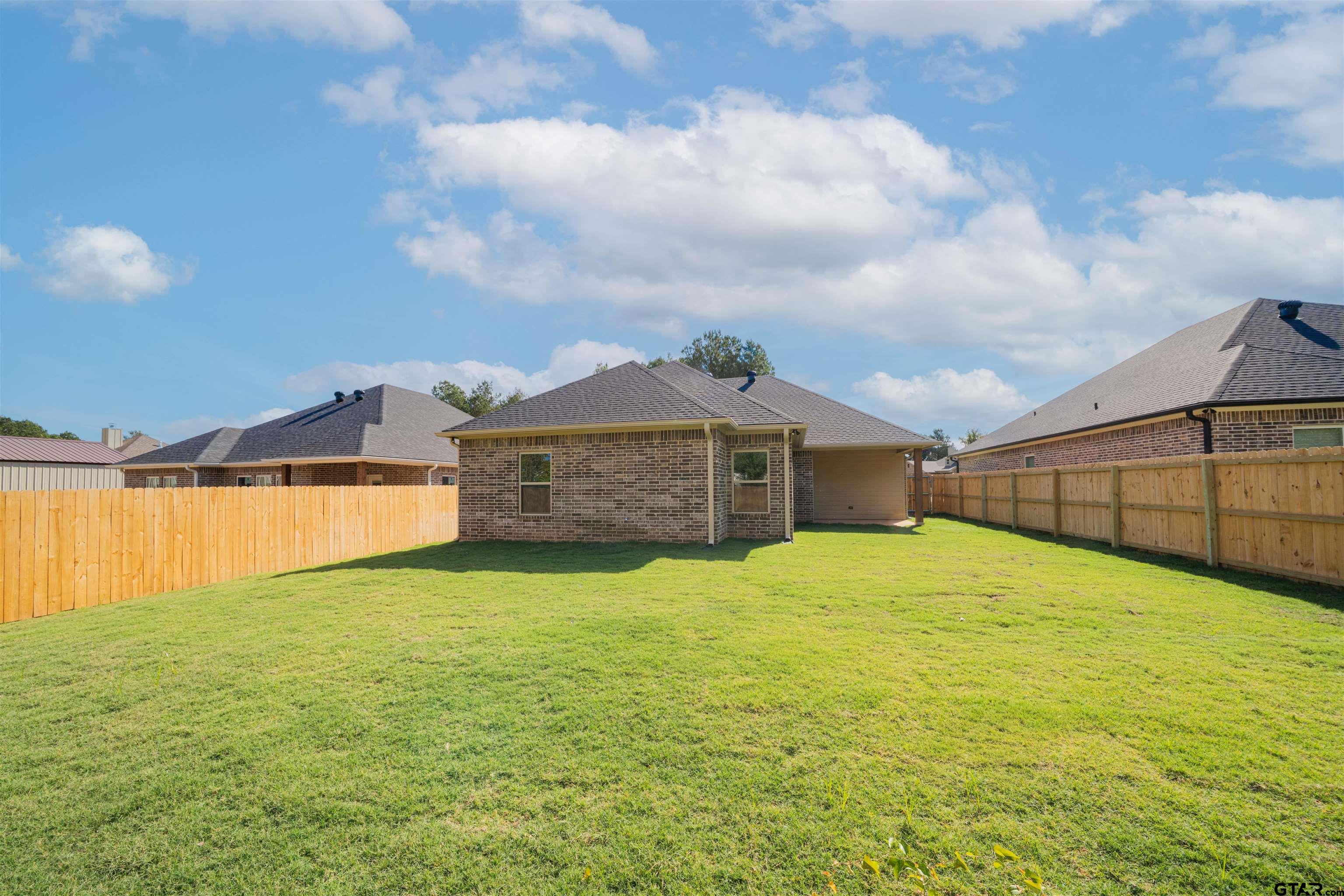 1203 Penny Lane Kilgore, TX 75662 - Photo 23 of 24 a view of a house with a yard and garage