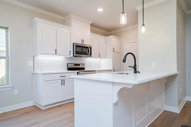 a kitchen with a sink stainless steel appliances and cabinets