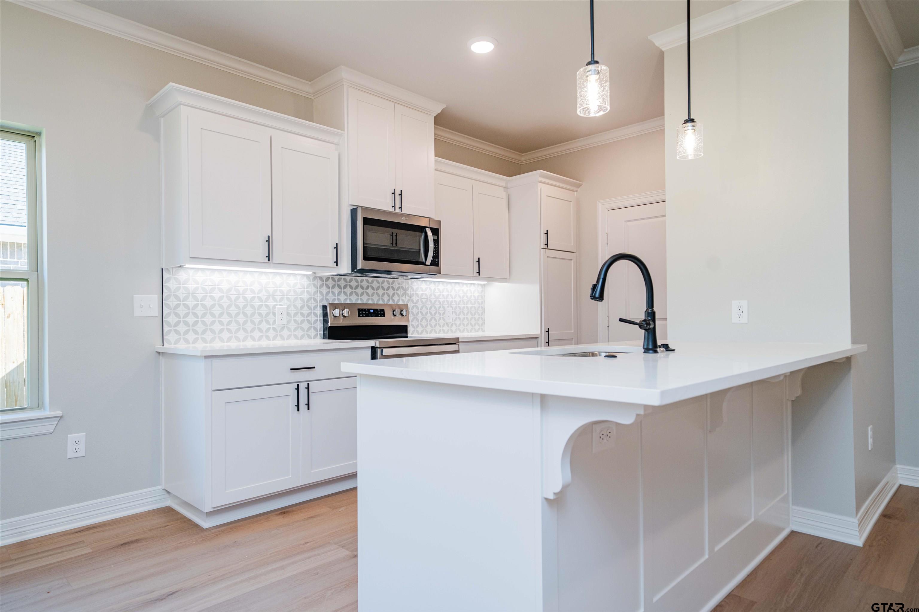 1203 Penny Lane Kilgore, TX 75662 - Photo 6 of 24 a kitchen with a sink stainless steel appliances and cabinets