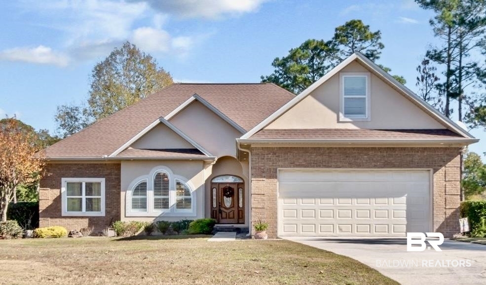 9905 Carnoustie Court Foley, AL 36535 - Photo 1 of 31 Traditional-style house featuring a front lawn, driveway, a shingled roof, and stucco siding
