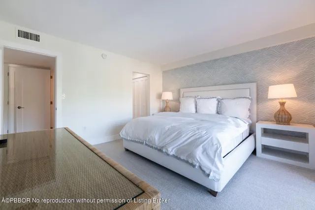 a large bed sitting in a bedroom next to a lamp