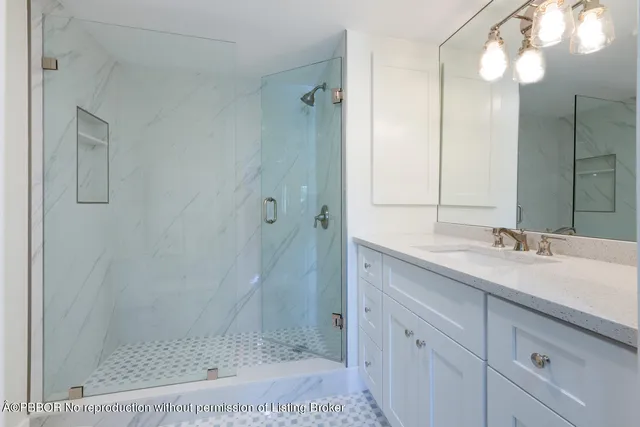 a bathroom with a shower sink and mirror