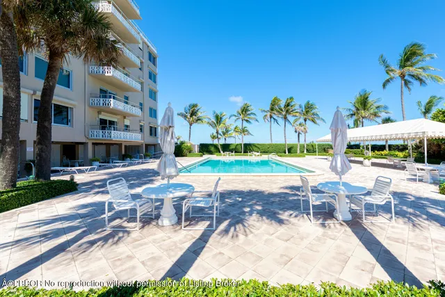 a view of a patio with a table and chairs under an umbrella