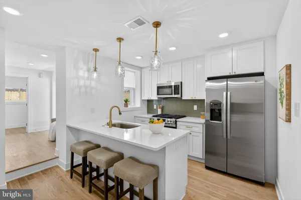 a kitchen with kitchen island a refrigerator stove microwave and cabinets