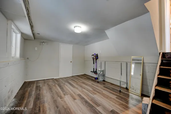 wooden floor with staircase and white walls