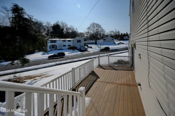 a view of a balcony with wooden floor and iron fence