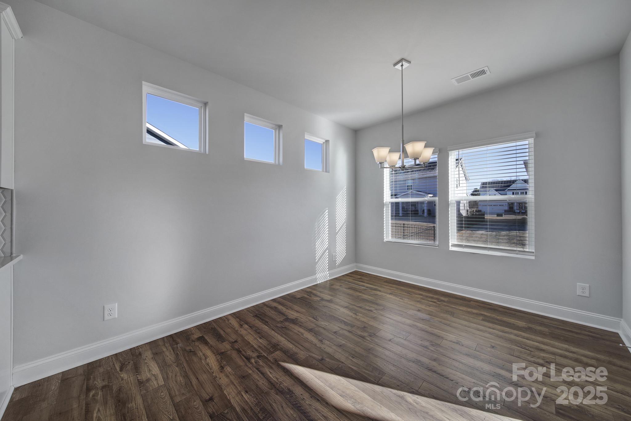 1112 Bradford Pear Road Monroe, NC 28112 - Photo 15 of 33 a view of an empty room with wooden floor and a window