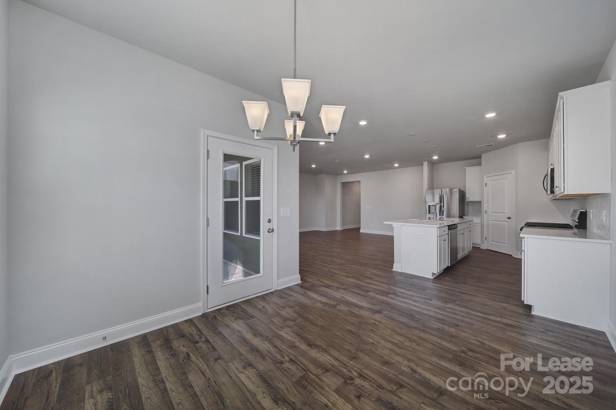 1112 Bradford Pear Road Monroe, NC 28112 - Photo 16 of 33 a view of a kitchen with kitchen island wooden floor and a chandelier