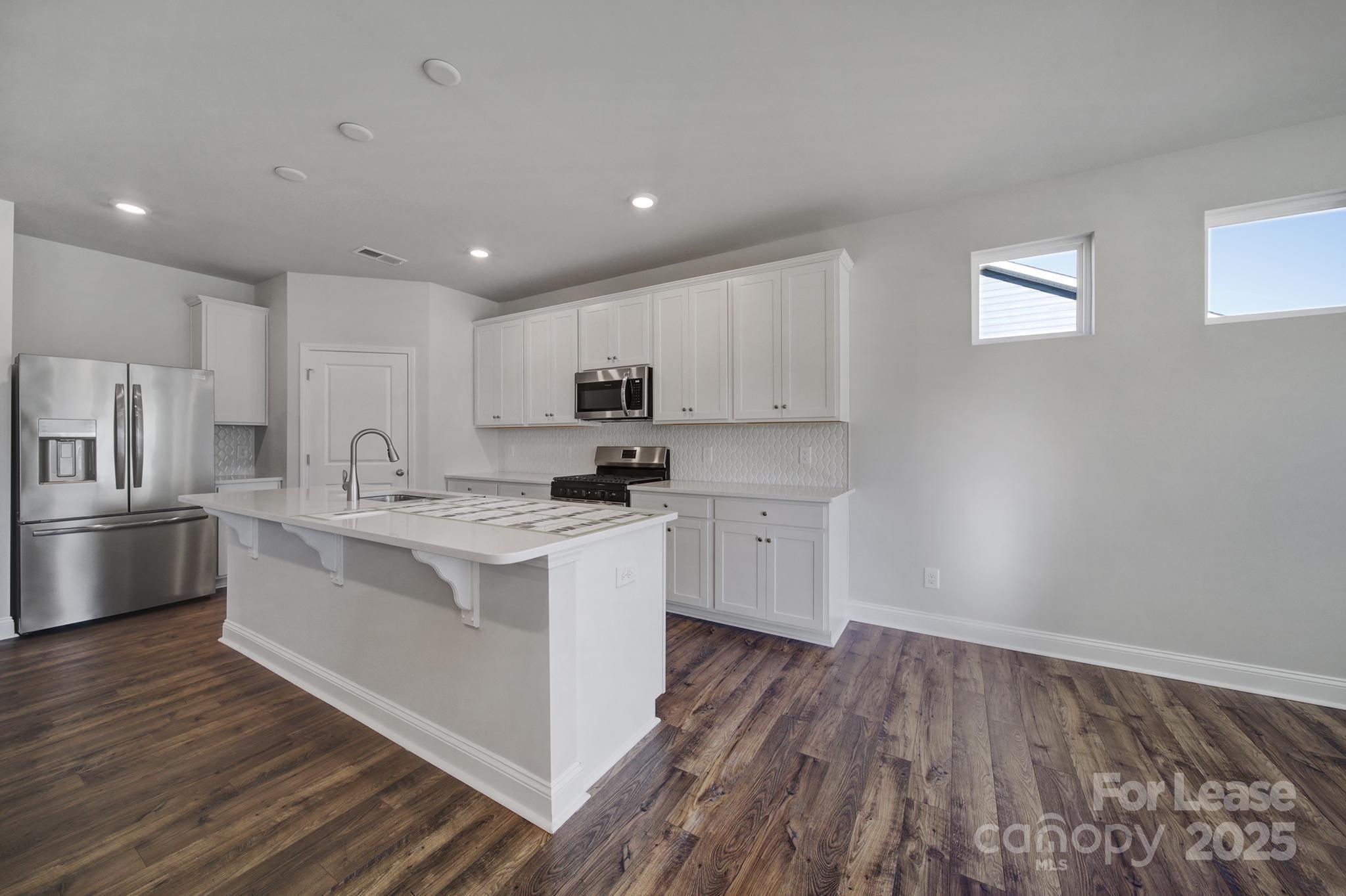 1112 Bradford Pear Road Monroe, NC 28112 - Photo 17 of 33 a kitchen with white cabinets appliances and wooden floor