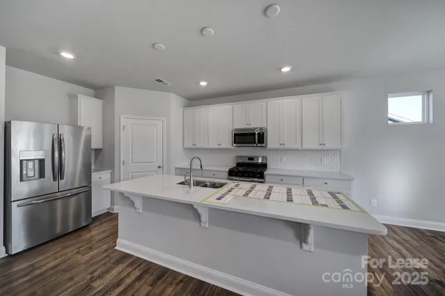 a kitchen that has a sink cabinets counter space and stainless steel appliances