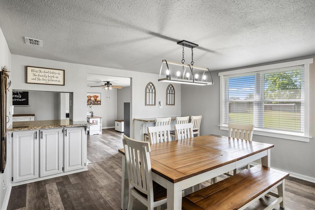 1216 VZ County Road Canton, TX 75103 - Photo 21 of 40 a dining room with wooden floor a chandelier a wooden table and chairs