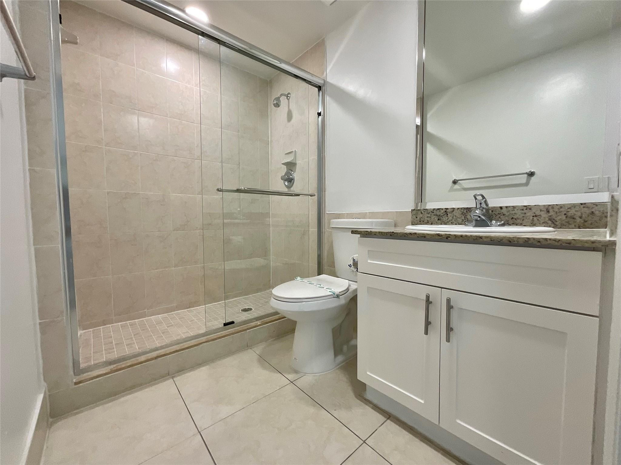 16900 North Bay Road, Unit 21211 Sunny Isles Beach, FL 33160 - Photo 8 of 30 a bathroom with a granite countertop sink a toilet and a shower