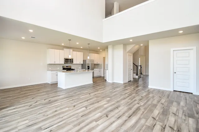 a view of kitchen view wooden floor and appliances