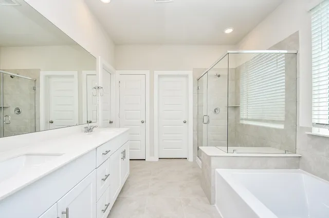 a spacious bathroom with a tub sink shower and mirror
