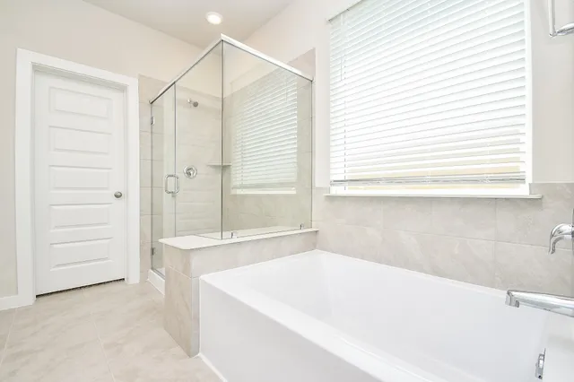 a bathroom with a tub a sink and a window